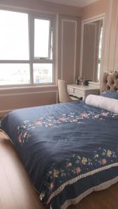 a bed with a blue blanket with flowers on it at S1-05A11A-Sapphire Hạ Long in Ha Long