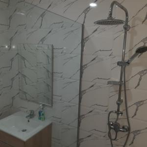 ein Bad mit einer Dusche und einem Waschbecken in der Unterkunft Ammira residence in Oran