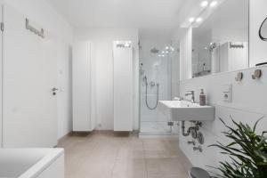 a white bathroom with a sink and a shower at Tolles Design & luxuriös, super komfortabel, 14 min Köln Zentrum (Bahn), Köln-Messe, Düsseldorf, Phantasialand in Hürth +23 photos
