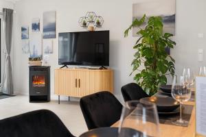 a living room with a tv and a table with a fireplace at Tolles Design & luxuriös, super komfortabel, 14 min Köln Zentrum (Bahn), Köln-Messe, Düsseldorf, Phantasialand in Hürth