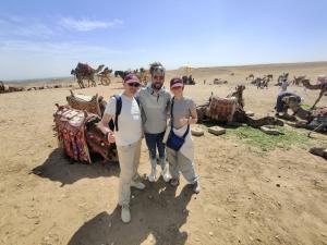 een man en twee vrouwen poseren voor een foto in de woestijn bij Eagles Pyramids View in Caïro