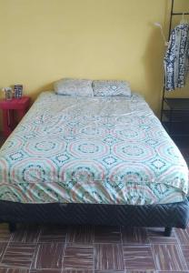 ein Bett mit einer Decke in einem Schlafzimmer in der Unterkunft Hostal Republic in Mérida