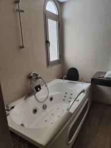 baño con bañera blanca y ventana en Maison Front de mer, en Martil