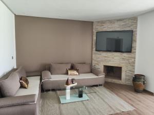 a living room with a couch and a fireplace at Maison Front de mer in Martil