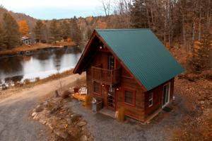 eine Luftansicht eines Blockhauses mit grünem Dach in der Unterkunft Refuge Private Hot Tub Lakeside in Grenville-sur-la-Rouge