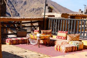 patio con mesa y sillas en el balcón en Kasbah Du Roches Armed en Imlil
