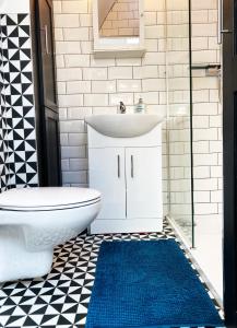 een badkamer met een wastafel, een toilet en een blauw tapijt bij BOUTIQUE DESIGNER STUDIO - close to city in Dublin