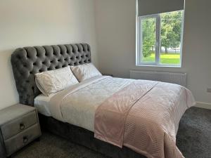 a bedroom with a large bed and a window at Modern design residence in Dublin