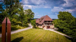 ein großes Haus mit einem Rasenplatz neben einer Straße in der Unterkunft Hotel Hofgut Hohenkarpfen in Hausen ob Verena