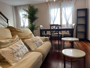 ein Wohnzimmer mit Sofa und Tisch in der Unterkunft Dúplex Pico Sacro in Lestedo