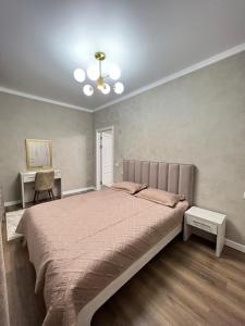 een slaapkamer met een groot bed en een bureau bij Элитная квартира в ЖК “Отау сити” in Simkent