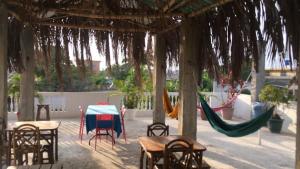 a patio with a table and chairs and a hammock at Estela, habitación privada de Flor de Lis Beach House in Playas