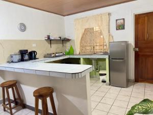 a kitchen with a counter and a refrigerator at Casa Quepos in Quepos
