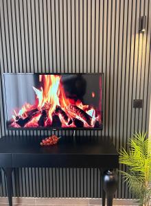 a tv sitting on top of a table with a fire at 12 rooms hotel in Köseilyas