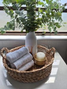 a basket with towels and a vase on a table at Nyala Bush Cabin in Polokwane