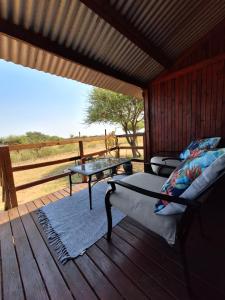 a bedroom with a bed and a table on a deck at Nyala Bush Cabin in Polokwane