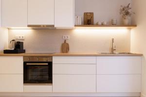 a kitchen with white cabinets and a sink at enδόtera chios apartments in Chios