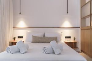 a bedroom with a large white bed with two pillows at enδόtera chios apartments in Chios