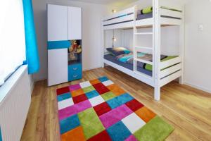 a colorful bedroom with a bunk bed and a colorful rug at House of the Rising Fun in Bubesheim
