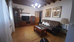 a living room with a couch and a tv at Casa da Pilar - A Ponte 