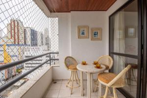 バウネアーリオ・コンボリウーにあるISO86B - Sacada com Churrasq, 2 DR Climatizadosのバルコニー(テーブル、椅子付)、窓が備わります。