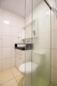 une salle de bain avec toilettes et douche en verre dans l'établissement JOA24 - 2 Dorm, Totalmente Climatizado, Garagem, à Balneário Camboriú