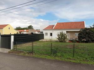 a house with a fence in front of a yard at Villa Gonçalo in Caldas da Rainha