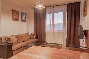 a living room with a couch and a tv at 2-room Apartment NFT Gudauri Penta 405 in Gudauri
