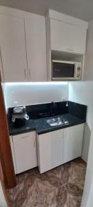 a small kitchen with a sink and a microwave at Residencial Vitor Studio 1 in São José dos Pinhais