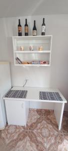 a white shelf with bottles of wine on it at Residencial Vitor Studio 1 in São José dos Pinhais