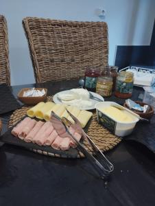 una mesa cubierta con queso, carne y utensilios en Casa azul, en Gouveia