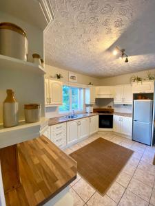 uma cozinha com armários brancos e um frigorífico azul em Seaview Bungalow em Donegal