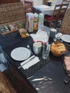 una mesa con platos de comida y una cesta de pan en Casa azul, en Gouveia