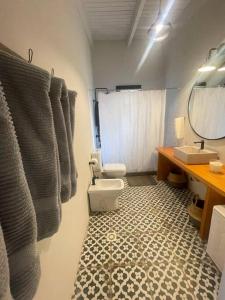 a bathroom with a toilet and a sink and a mirror at CASA NEGRA Jose Ignacio in José Ignacio