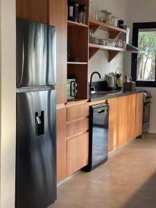a kitchen with a stainless steel refrigerator and a dishwasher at CASA NEGRA Jose Ignacio in José Ignacio