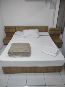 ein Bett mit zwei Kissen auf einem Zimmer in der Unterkunft AP da Cris cabo frio in Cabo Frio