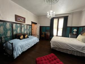 a bedroom with two beds and a chandelier at Bed and Breakfast Hearts Desire in Raton