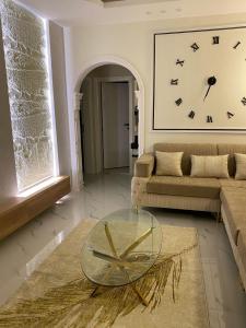 a living room with a couch and a clock on the wall at Fhr-105 in Al-Salam