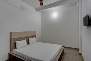 1 dormitorio con 1 cama blanca en una habitación en OYO Sky Line en Ghaziabad