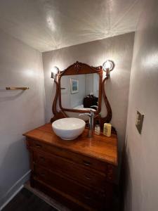 een badkamer met een wastafel en een spiegel op een dressoir bij Bed and Breakfast Hearts Desire in Raton