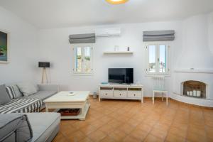 Televízia a/alebo spoločenská miestnosť v ubytovaní Cycladic Luxurious Maisonette