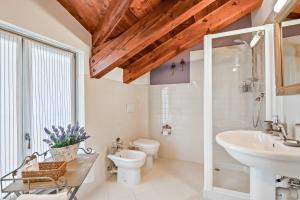 a white bathroom with a sink and a toilet at Affittacamere La Collina Degli Ulivi in La Spezia