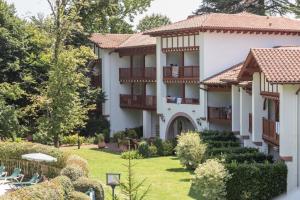 a large white building with a yard with chairs at Résidence Le Parc d'Arradoy - maeva Home - Appartement 2 pièces 4 personnes - Confort MAE-5971 in Uhart-Cize