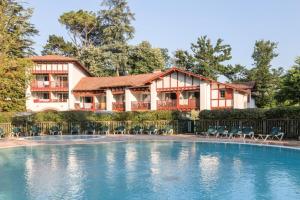 a house with a swimming pool in front of a house at Résidence Le Parc d'Arradoy - maeva Home - Appartement 2 pièces 4 personnes - Confort MAE-5971 in Uhart-Cize