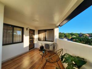 an empty room with two chairs and a balcony at Las Arecas - 3° B in Puerto Iguazú