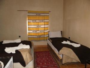 Uma cama ou camas num quarto em Auberge Sahara