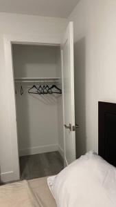 Dormitorio blanco con cama y armario en 1 bedroom w/ shared space, en Halifax
