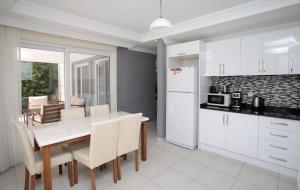 a kitchen and dining room with a white table and chairs at Villa Raya 1 in Fethiye