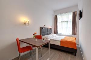 a bedroom with a bed and a table and a bed and a window at Aparthotel Bianca in Vienna