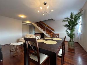 ein Esszimmer mit einem Tisch und einer Treppe in der Unterkunft Dúplex Pico Sacro in Lestedo + 8 Fotos